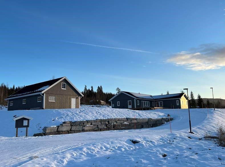 Viser huset på Båsrøsta i vinterlandskap med blå himmel - Klikk for stort bilde