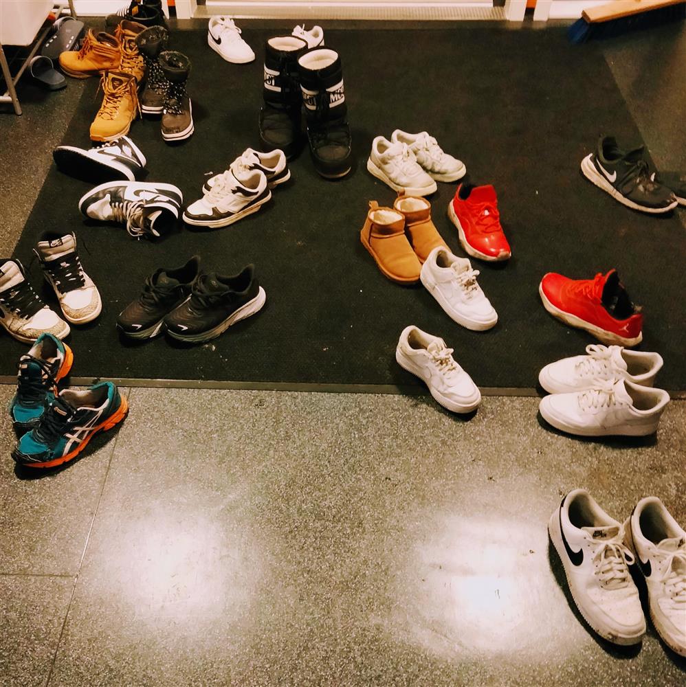 Viser inngangspartiet til fritidsklubben med 18 par sko liggende utover gulvet - Klikk for stort bilde